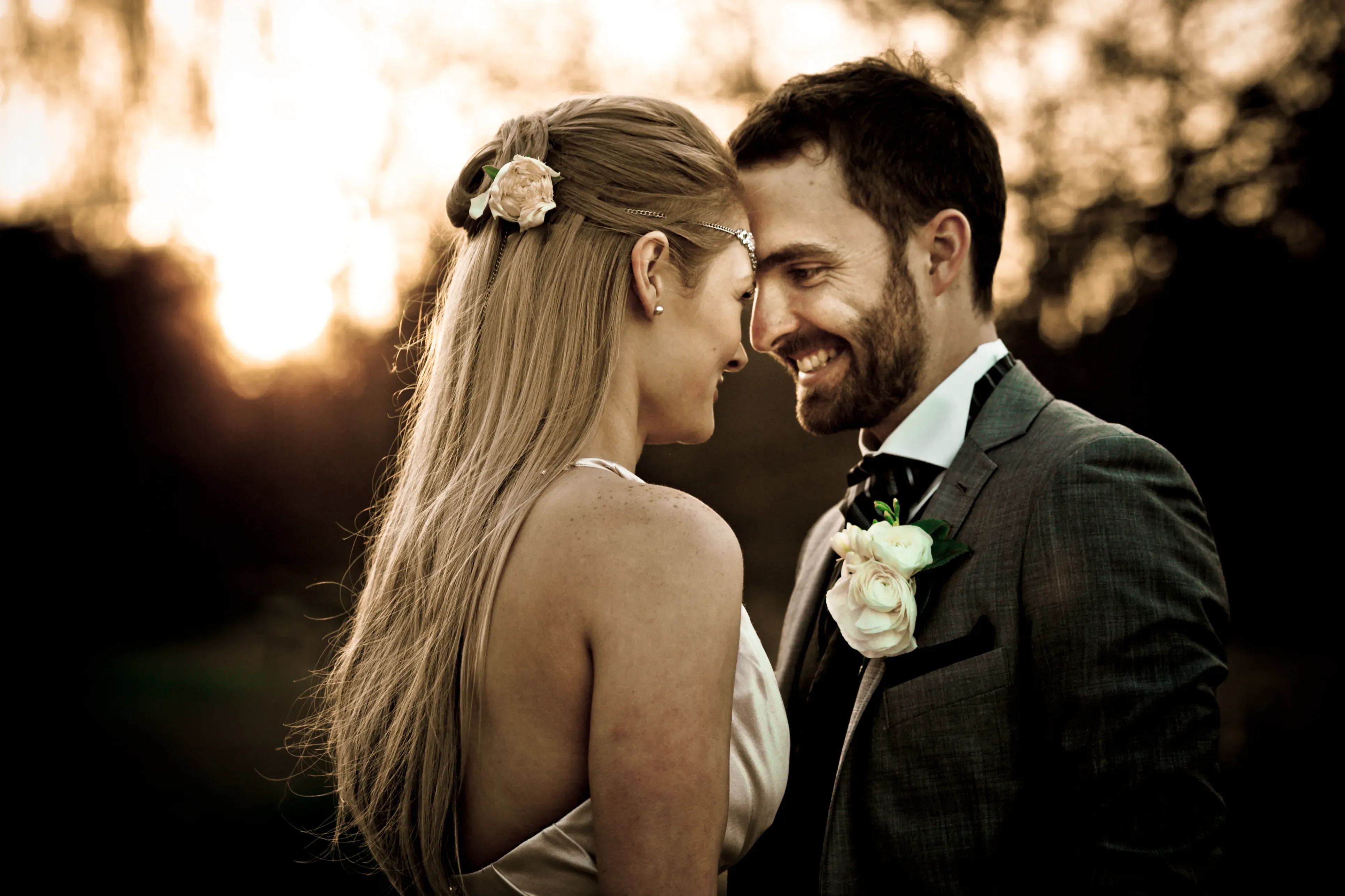 A couple forehead to forehead in the last of the light, the bride’s hair styled by Amanda Frost