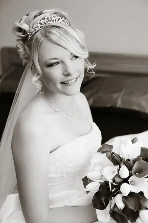 Bride in a tiara and full length veil, her blonde hair pinned with soft curls at the crown