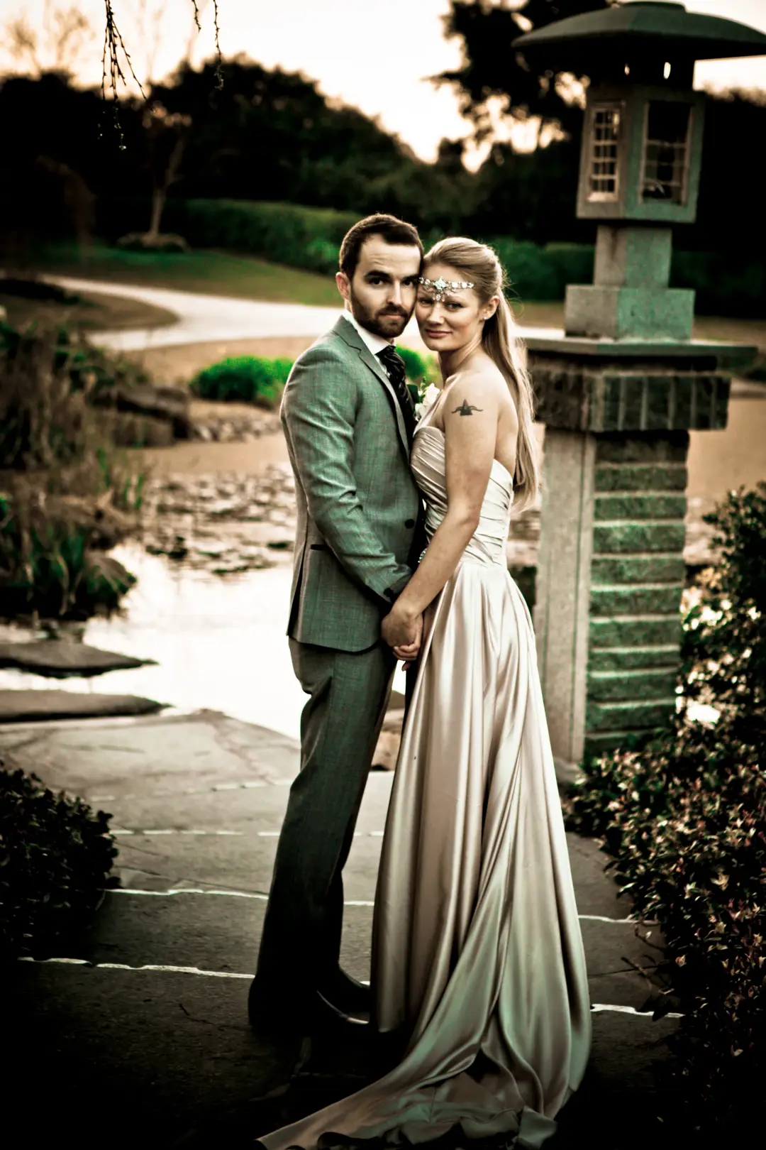 Bride and groom in a Japanese garden at dusk, her long hair loose beneath a beaded browband