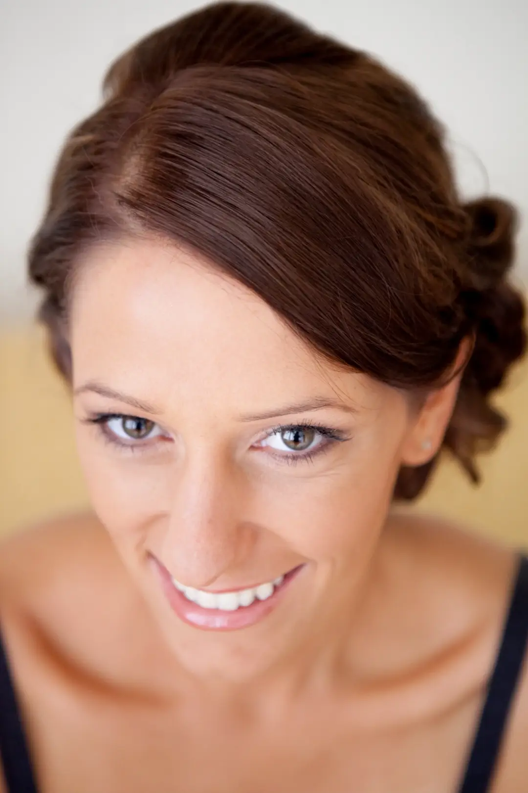Guest with brunette hair swept into a low twisted knot, wearing soft everyday makeup