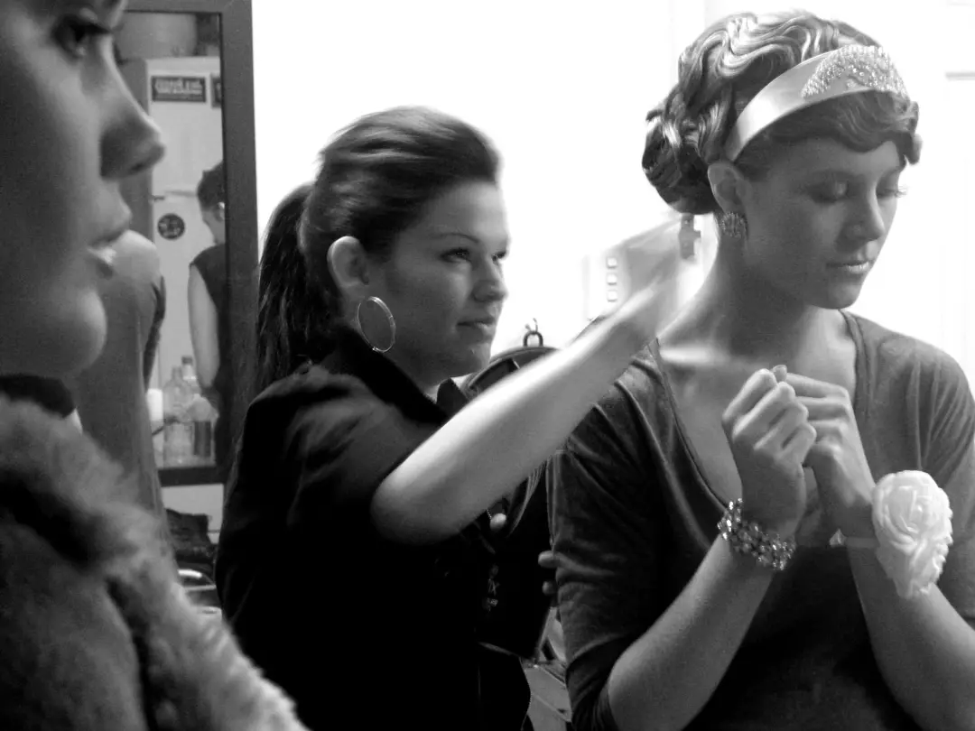 Hair being set on location with the client's curls pinned under a patterned scarf