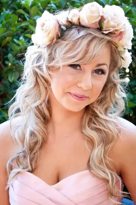 Bridesmaid in a rose crown with long blonde curls worn loose, in a blush gown