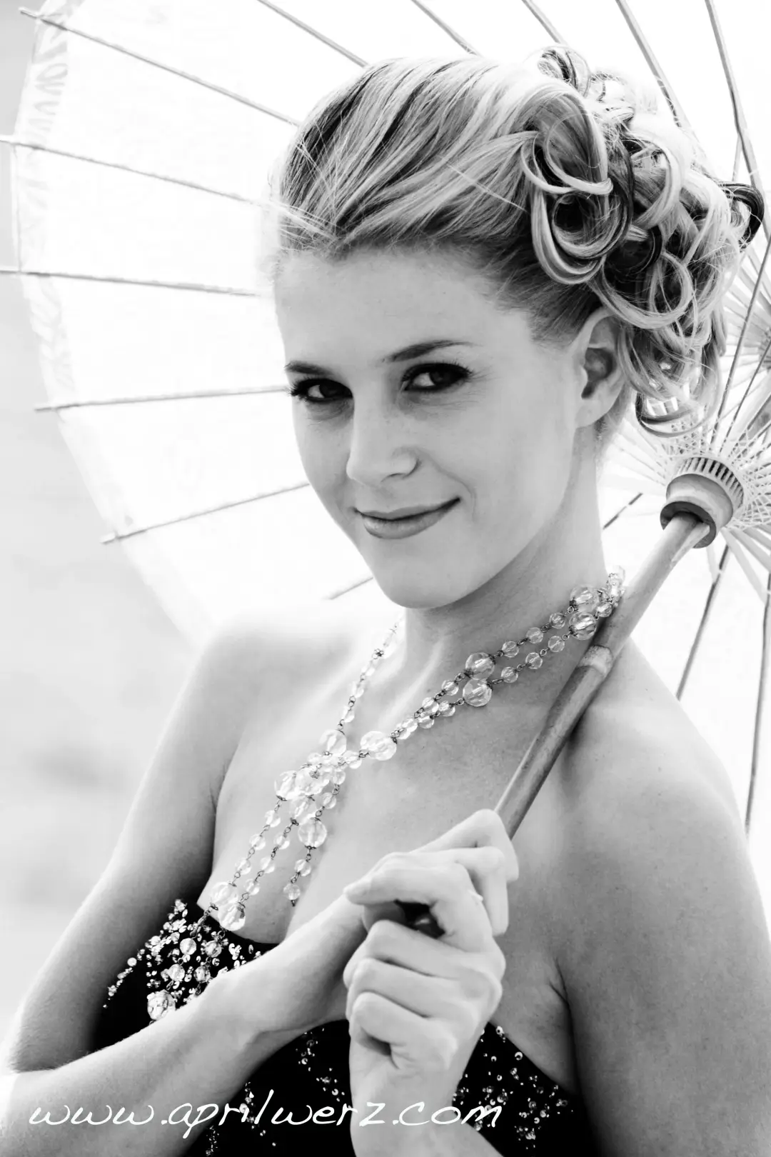Guest with a parasol, her blonde hair rolled into a vintage curled updo