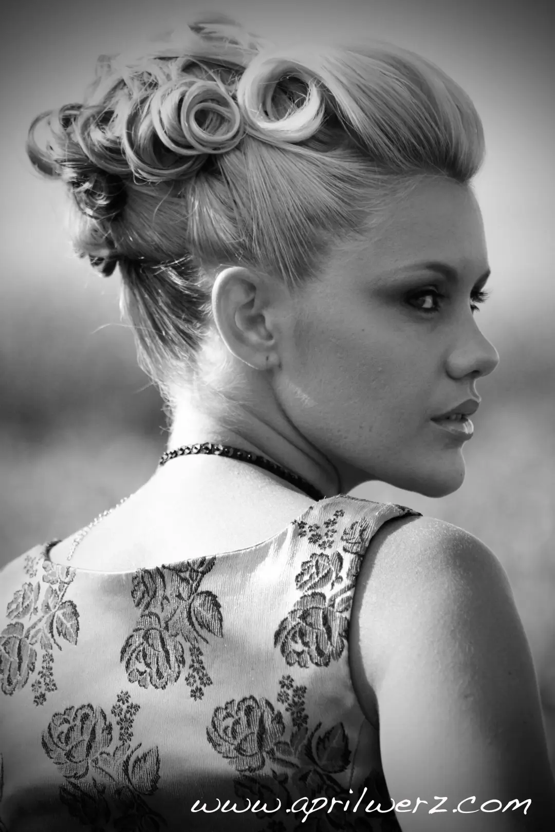Blonde curls rolled into a high vintage updo, photographed in profile