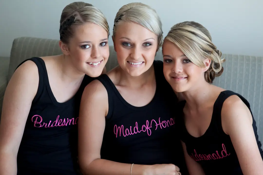Bridesmaids and the maid of honour in printed singlets, hair and makeup finished before dressing