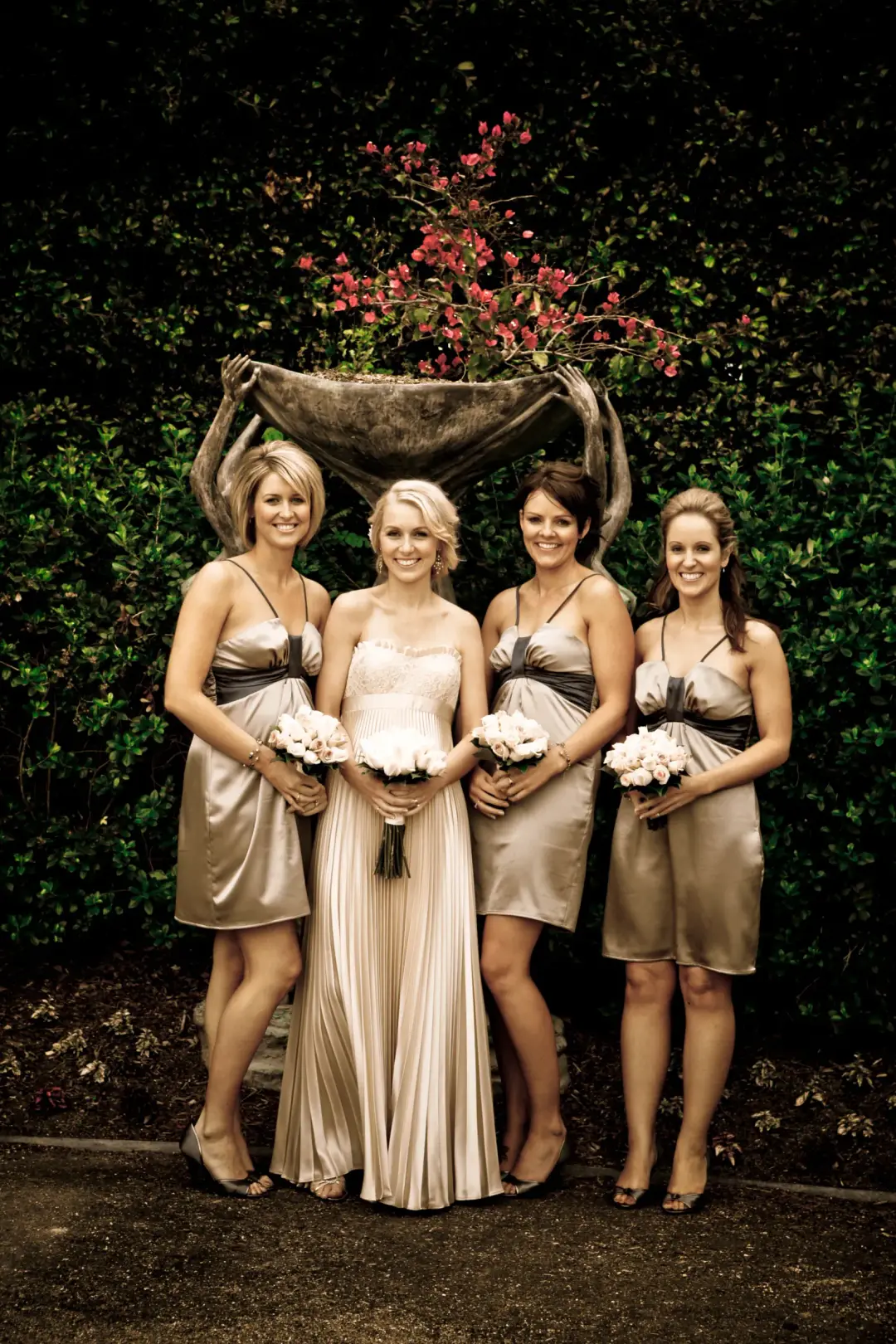 Bride and three bridesmaids in gold satin, all four styled with their hair pinned up