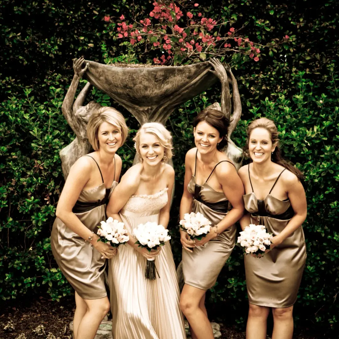 Bride and three bridesmaids in gold satin, every one styled with her hair pinned up