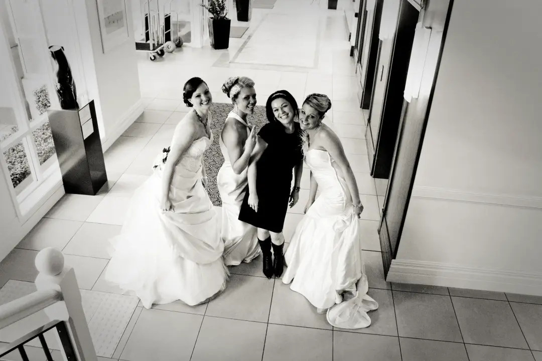 Bride and bridesmaids gathered in the hallway on the wedding morning, all styled and dressed