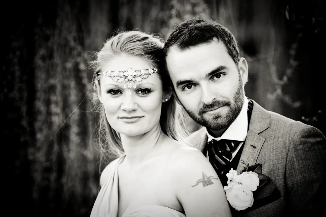 Bride and groom portrait, the bride wearing a beaded headband across her forehead with her hair long and loose