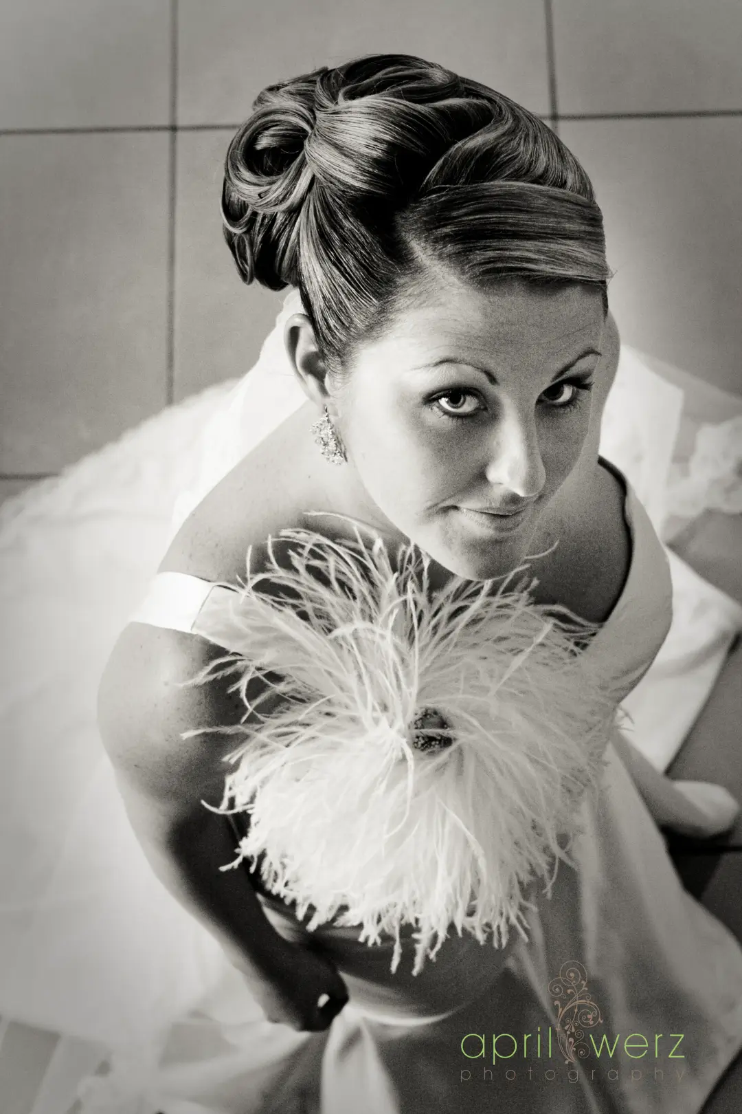 Bride photographed from above in a vintage rolled updo, holding a feather fan