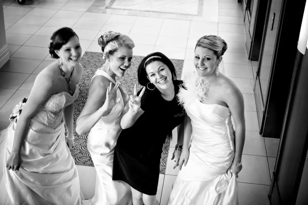 Bride, bridesmaids and their stylist laughing together, every one styled for the morning