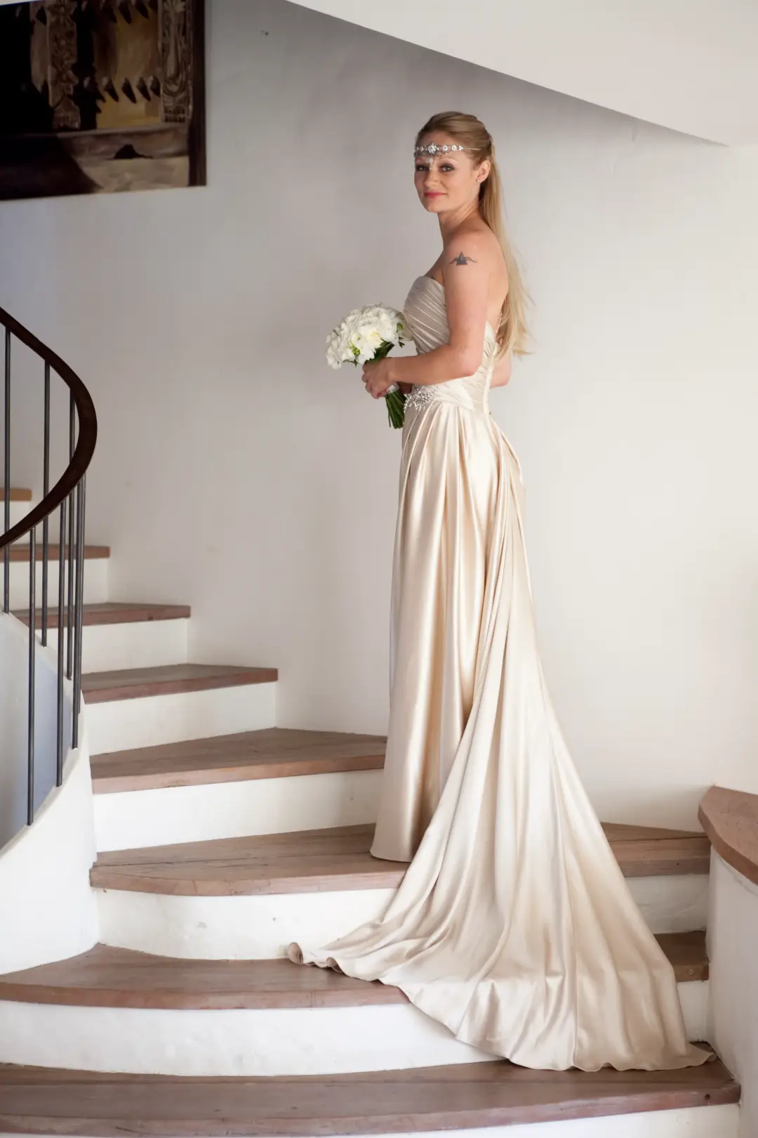 Guest on the stairs in a satin gown, her long hair worn down with a jewelled browband