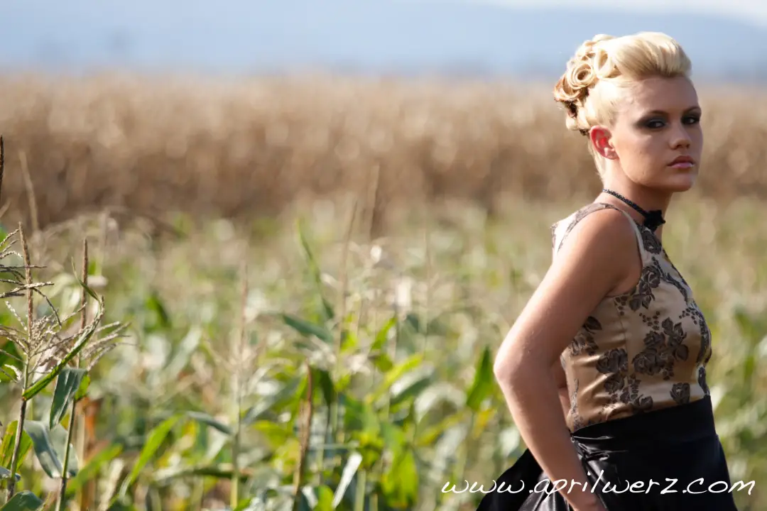 Guest in a paddock with her blonde hair styled into a curled and pinned updo