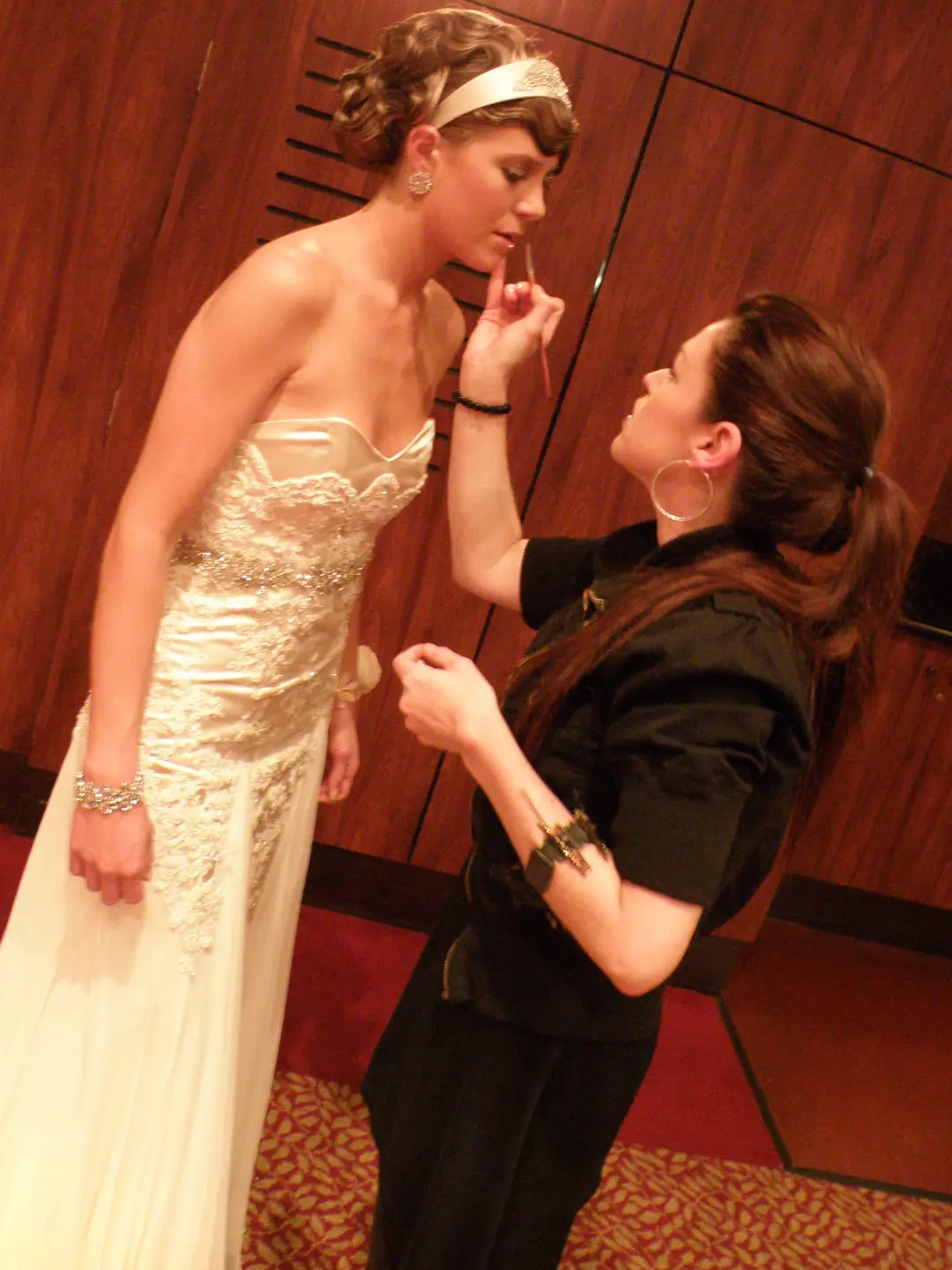 Formal makeup applied on location, the client wearing a gold headband over a soft pinned style