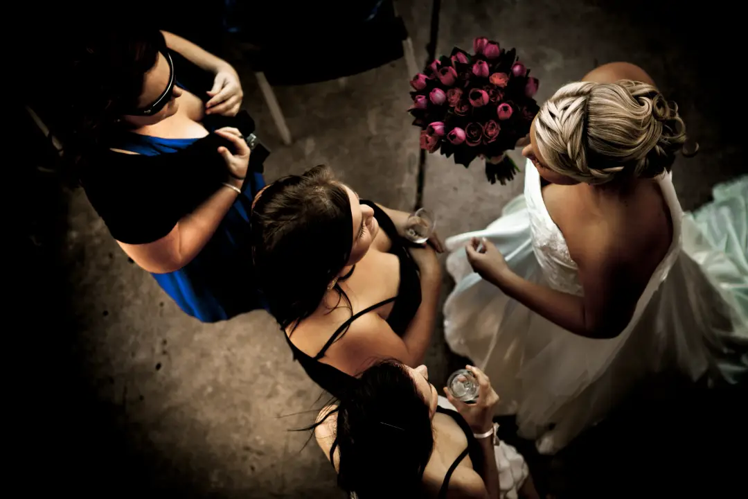 Bride and her bridesmaids photographed from above, hair pinned into a braided updo