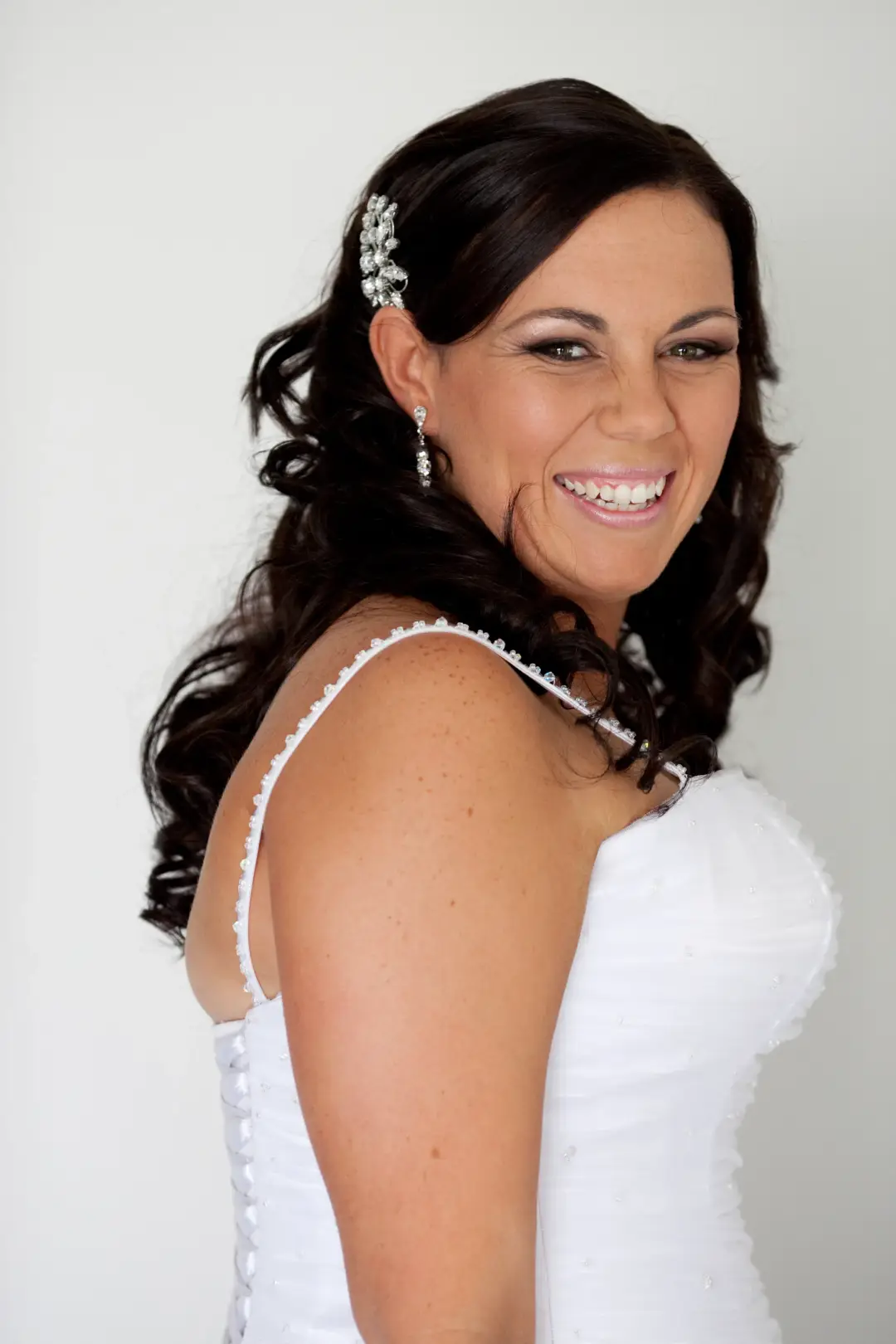 Bride with long dark curls worn half up, pinned with a diamante clip