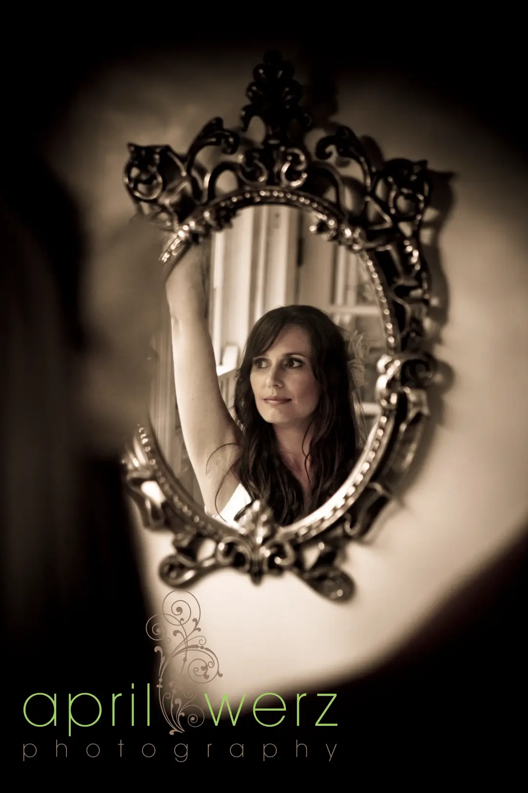 Bride reflected in an ornate mirror, her long dark hair worn down in soft waves