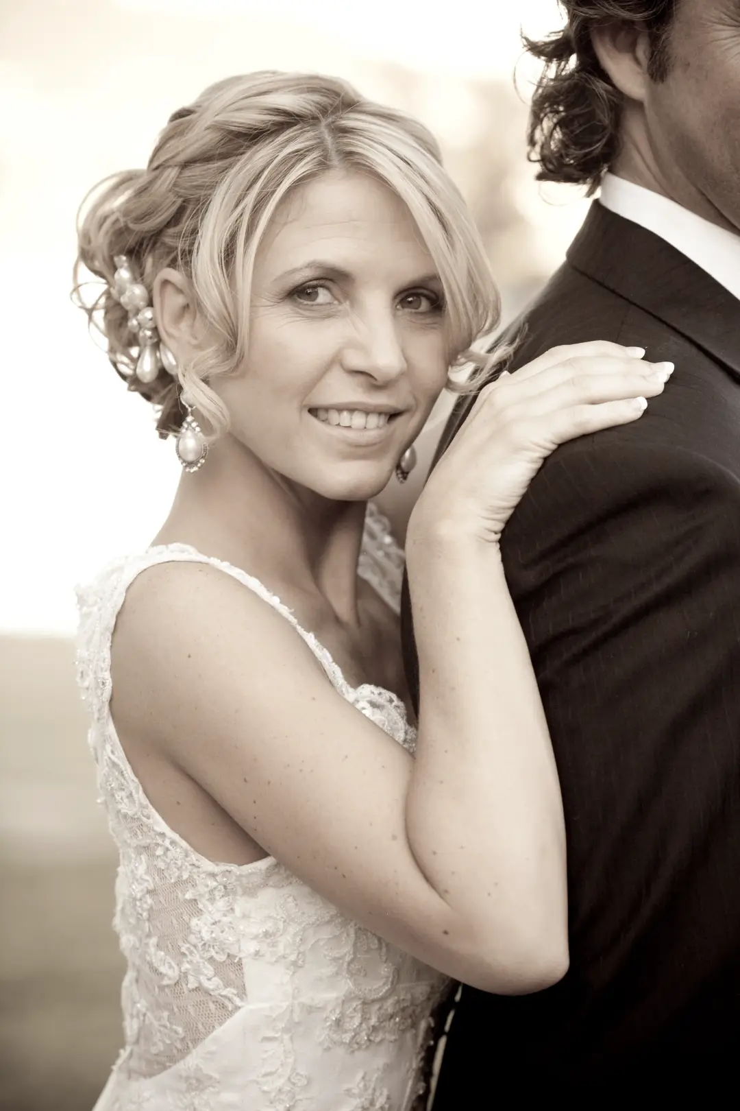 Hunter Valley bride with a braided and pinned updo dressed with small flowers, in a lace gown, by Amanda Frost of Bellus