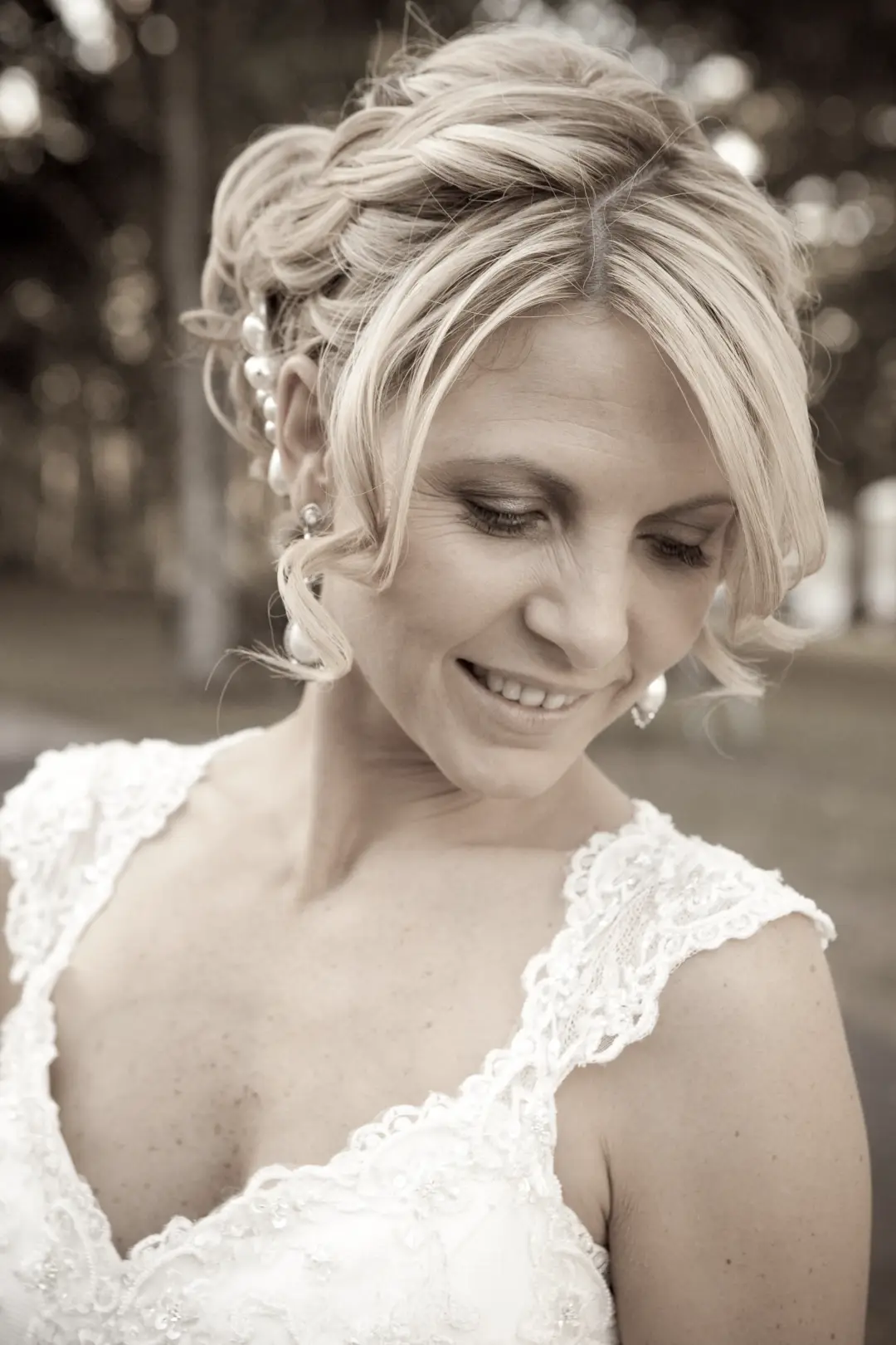 Hunter Valley bride in a braided updo threaded with pearl pins, wearing soft natural makeup and a lace gown, by Amanda Frost of Bellus